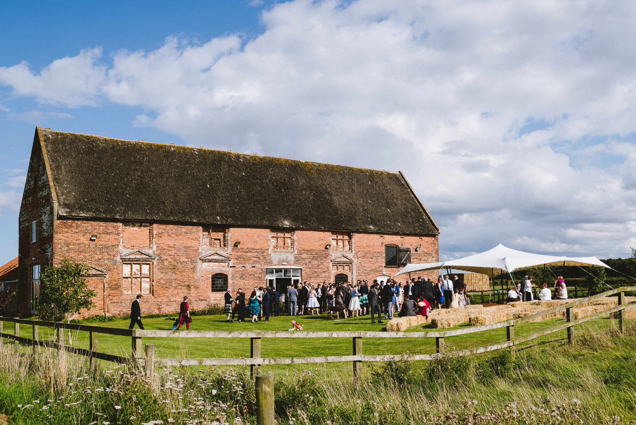 Wedding guests outside rustic brick barn venue